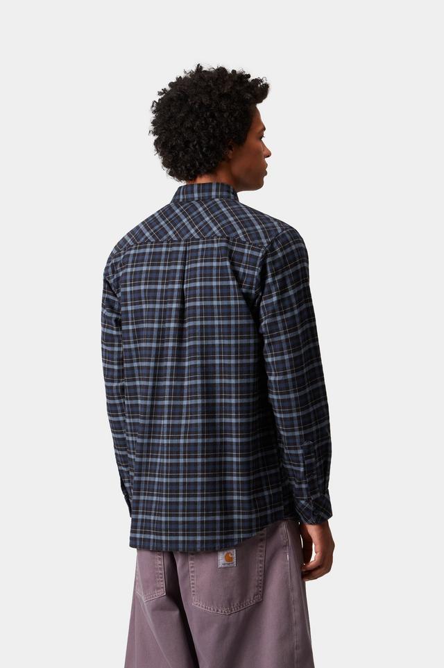 Person wearing a plaid shirt and Carhartt pants on a white background