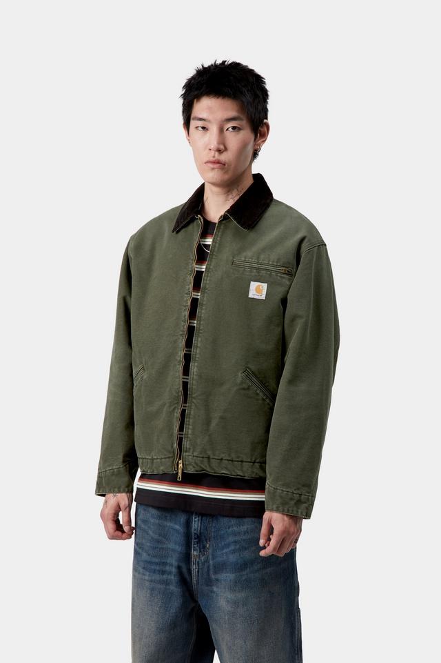 Person wearing a green jacket with a brand logo on a white background