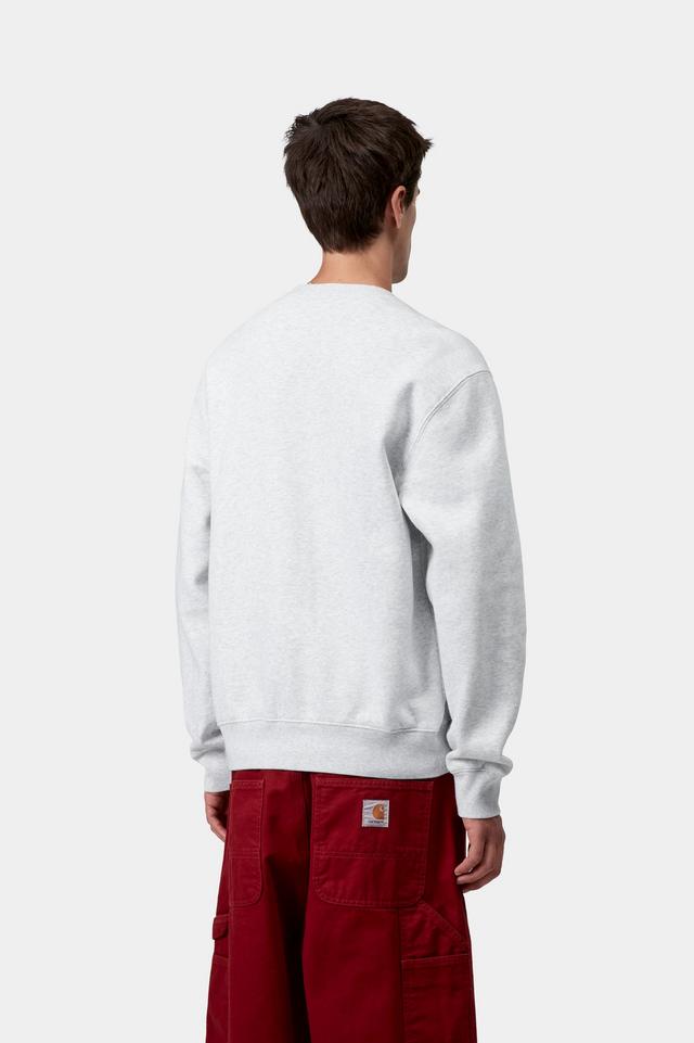 Person wearing a light grey sweatshirt and red pants on a white background