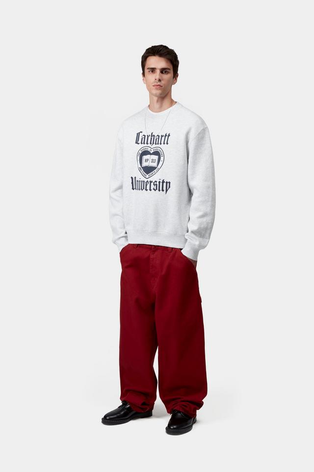 Person wearing a light grey sweatshirt with text and red pants on a white background