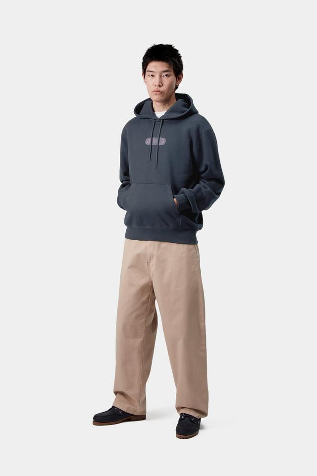 Person wearing a dark blue hoodie and beige pants on a white background