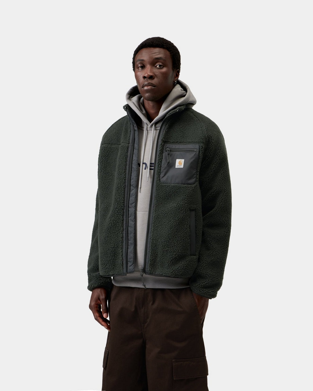 Carhartt WIP Prentis Liner in Raven / Black, front view, with a zip front, funnel neck, chest pocket, and woven logo patch, shown on model.