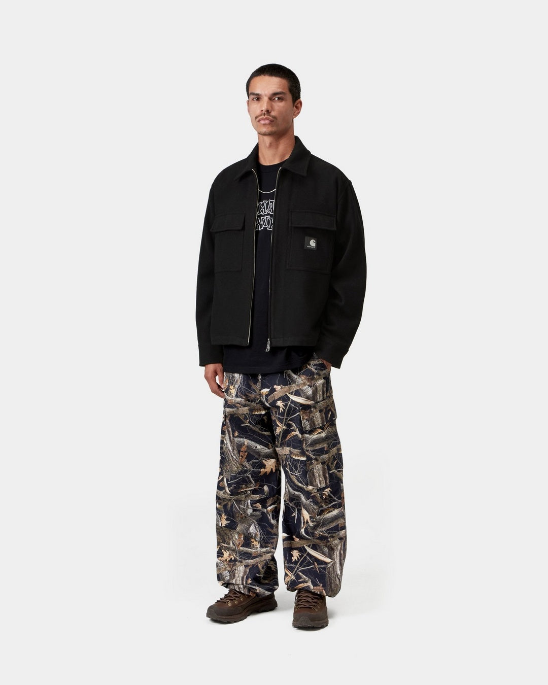 Model wearing Carhartt WIP Atoka Shirt Jac in Black, front view with two-way zip open, showing chest flap pockets and Square Label.