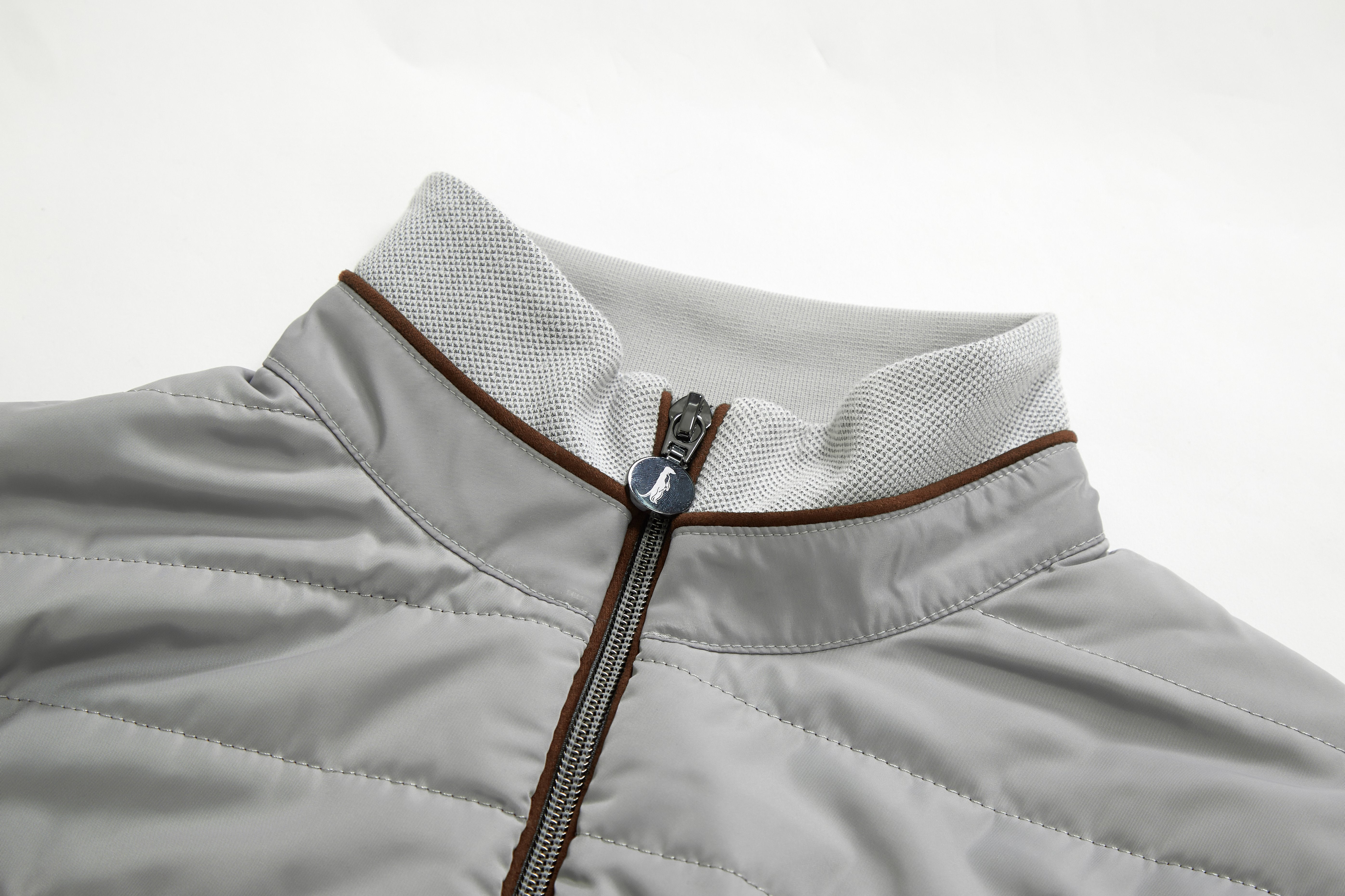Close-up of a silver jacket with a zipper on a light gray background