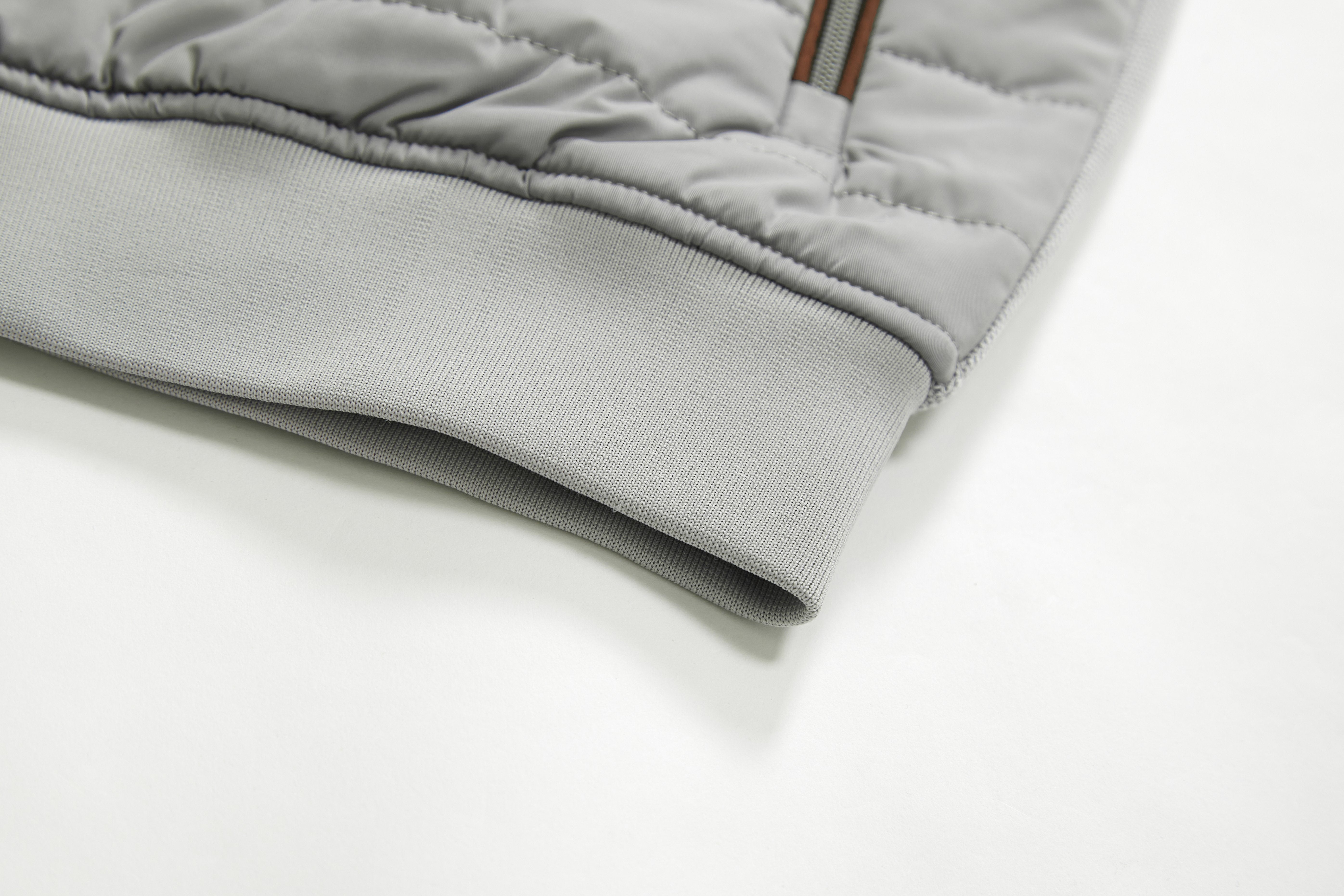 Close-up of a gray quilted jacket on a white background
