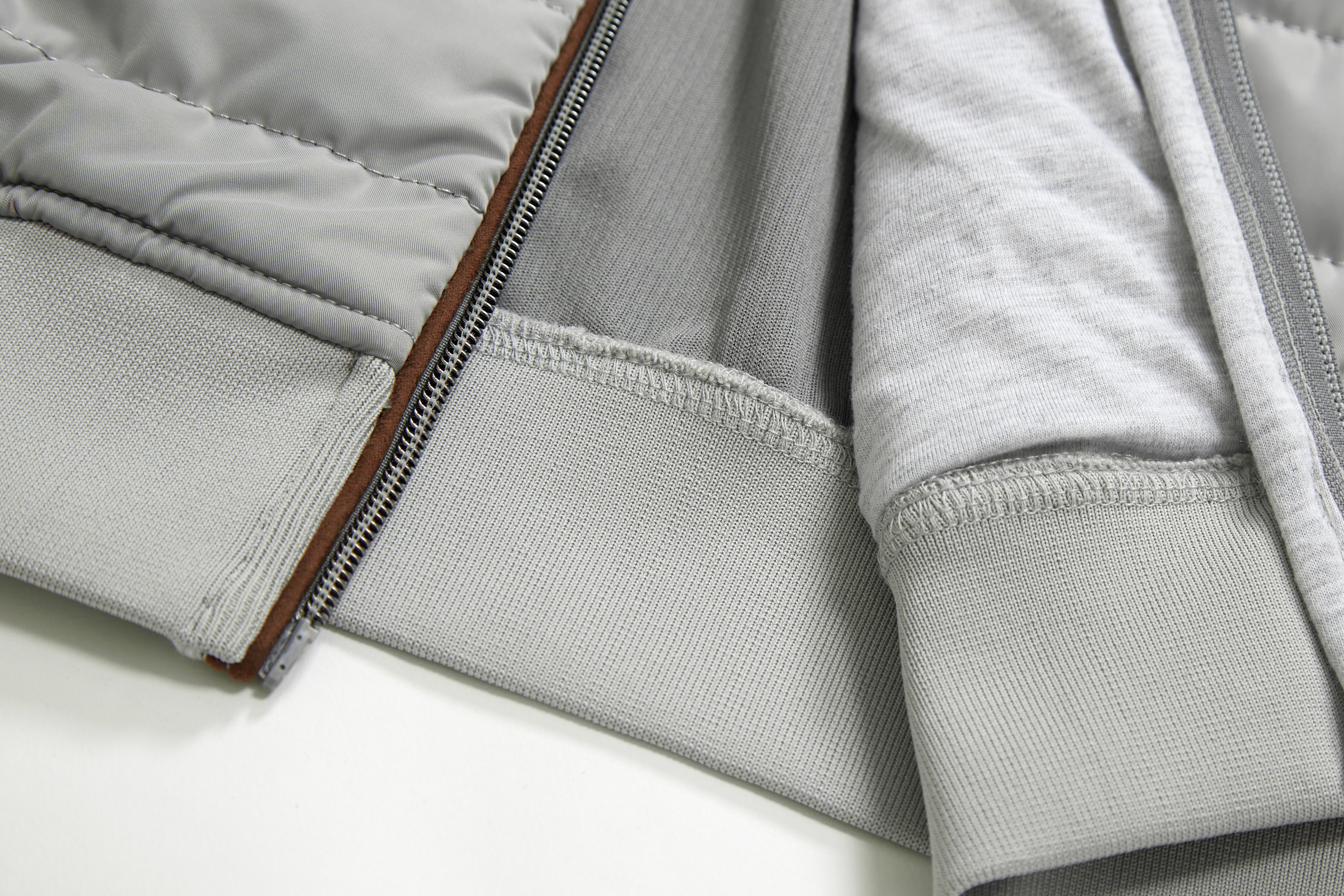 Close-up of a gray jacket with a zipper on a white background