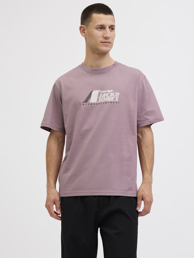 Man wearing a mauve t-shirt with a logo on a white background