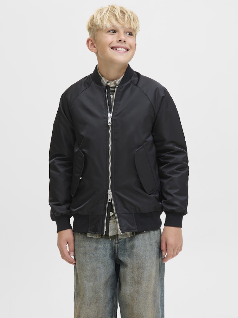 Child wearing a black jacket on a plain background