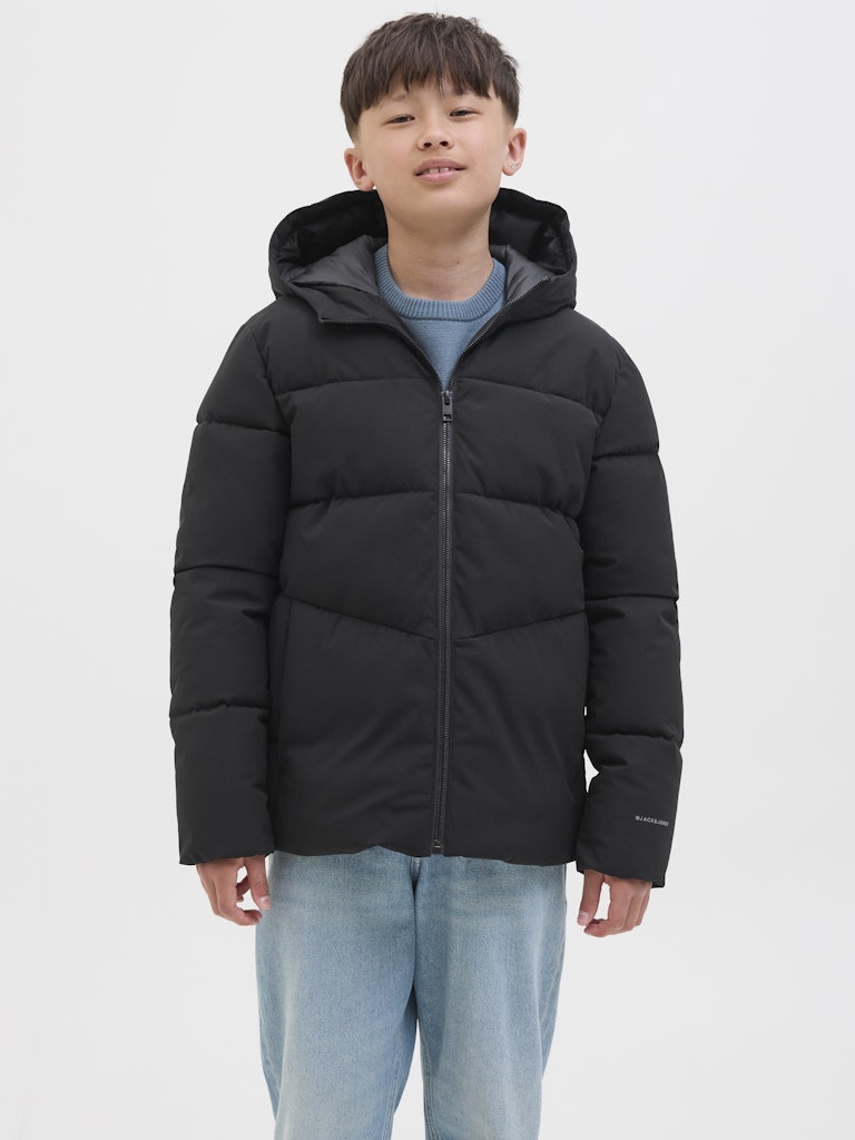 Person wearing a black puffer jacket on a white background