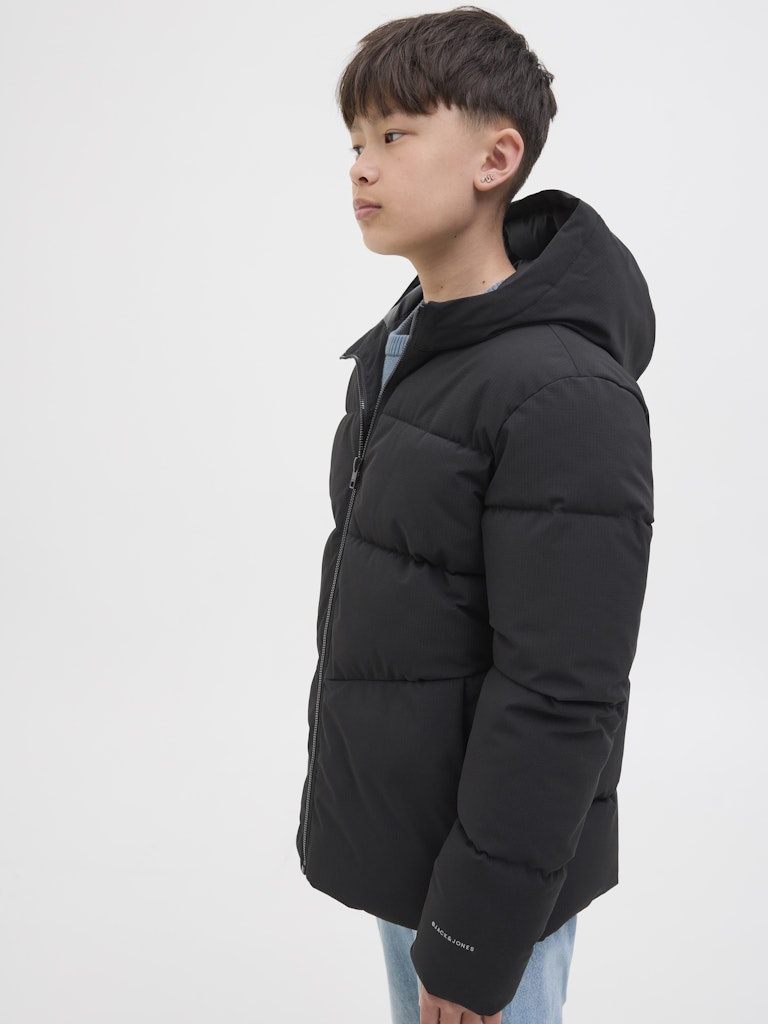Child wearing a black puffer jacket on a white background