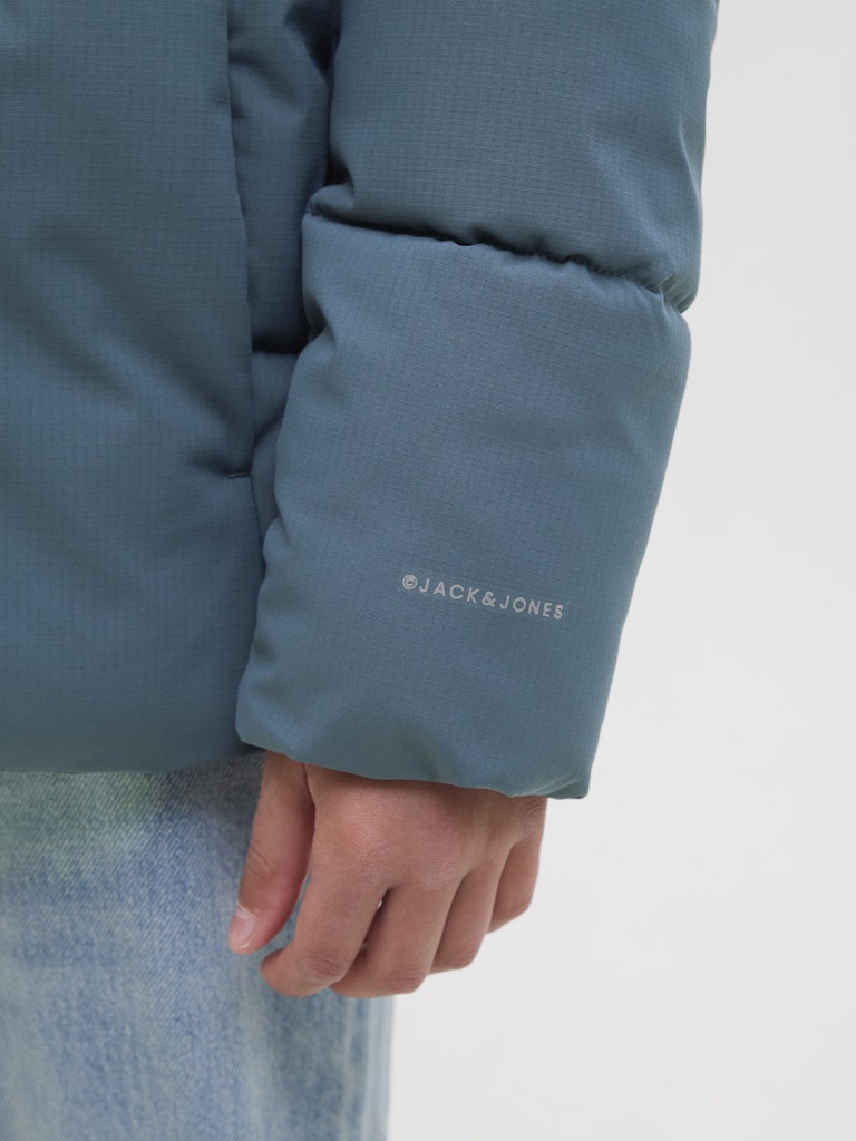 Close-up of a blue jacket sleeve with 'Jack & Jones' branding on a white background