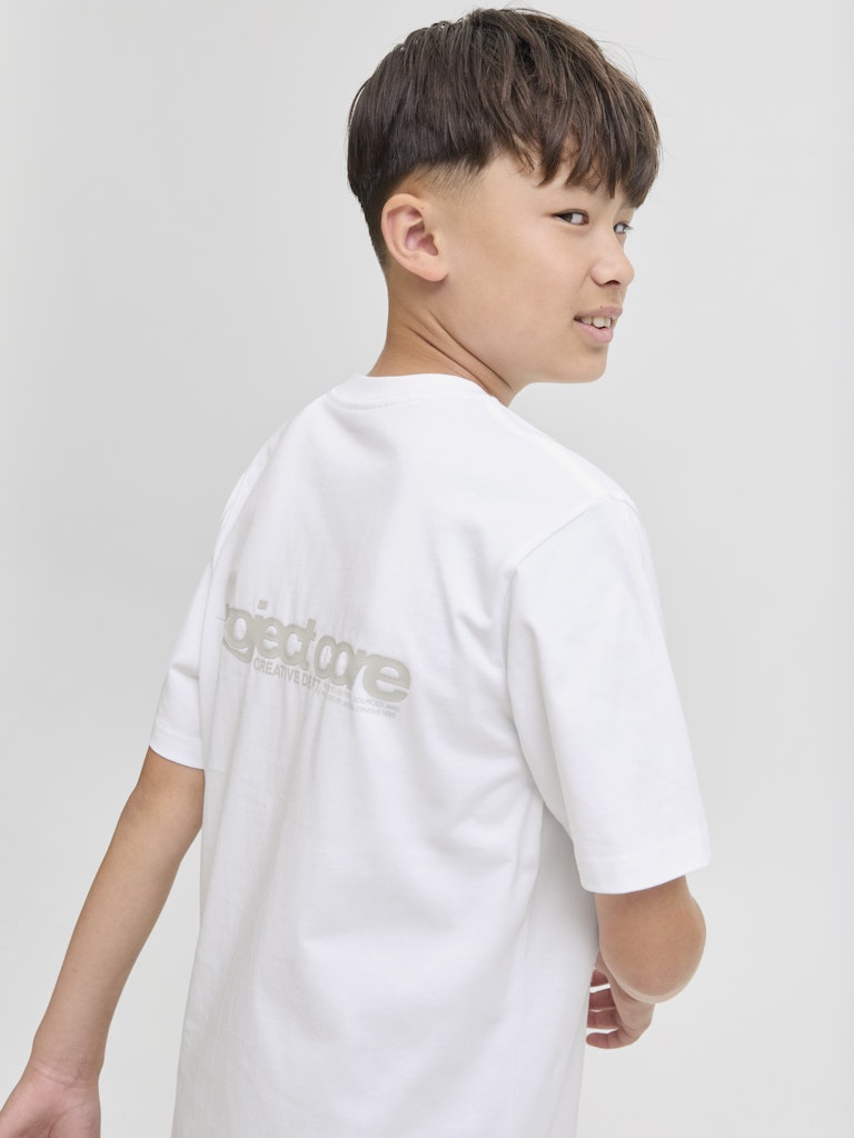 Child wearing a white t-shirt with a logo on the back against a plain background