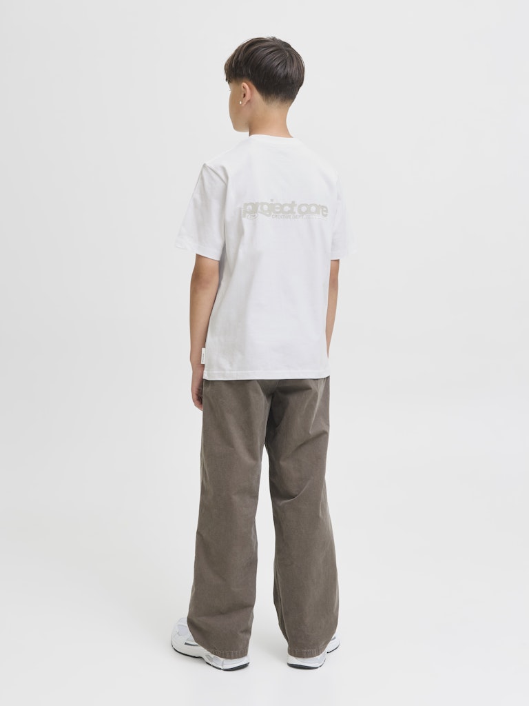 Person wearing a white t-shirt with text and brown pants on a white background