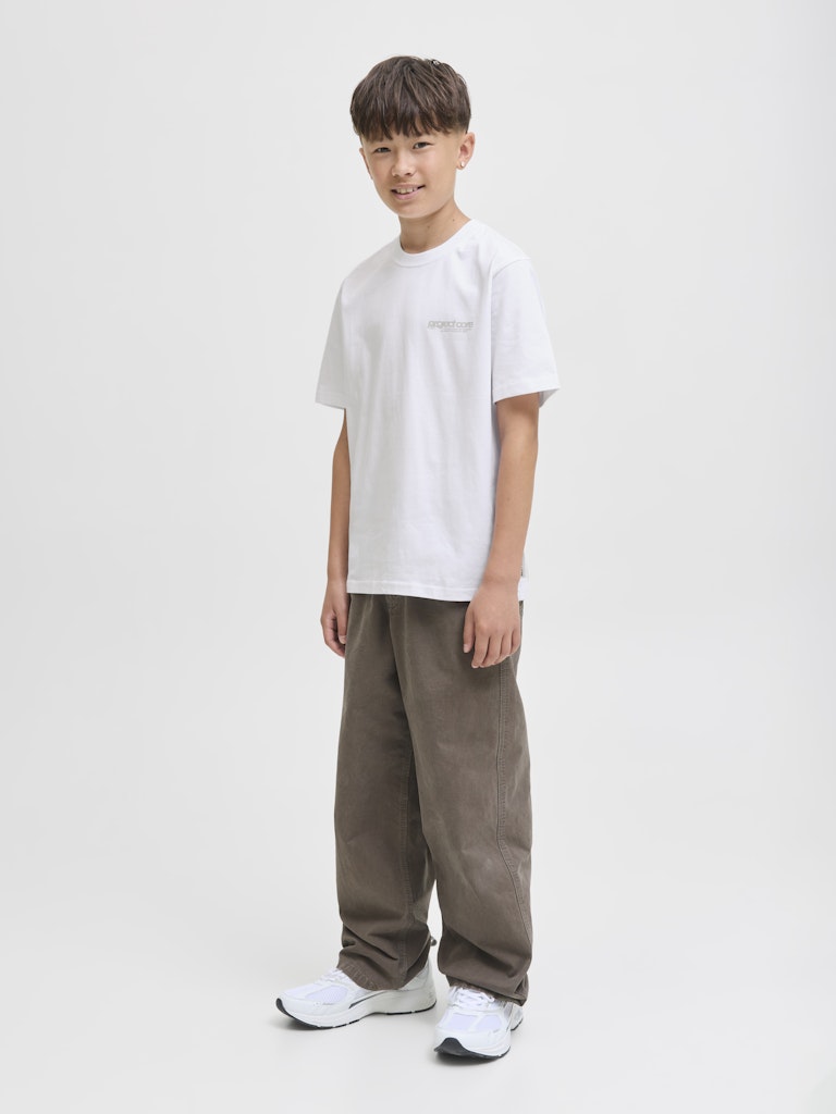 Person wearing a white t-shirt and brown pants on a plain background