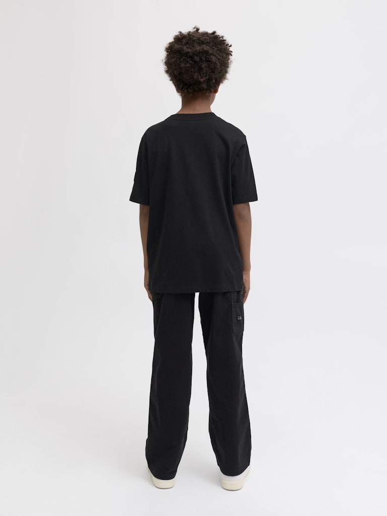 Person wearing a black t-shirt and black pants on a white background
