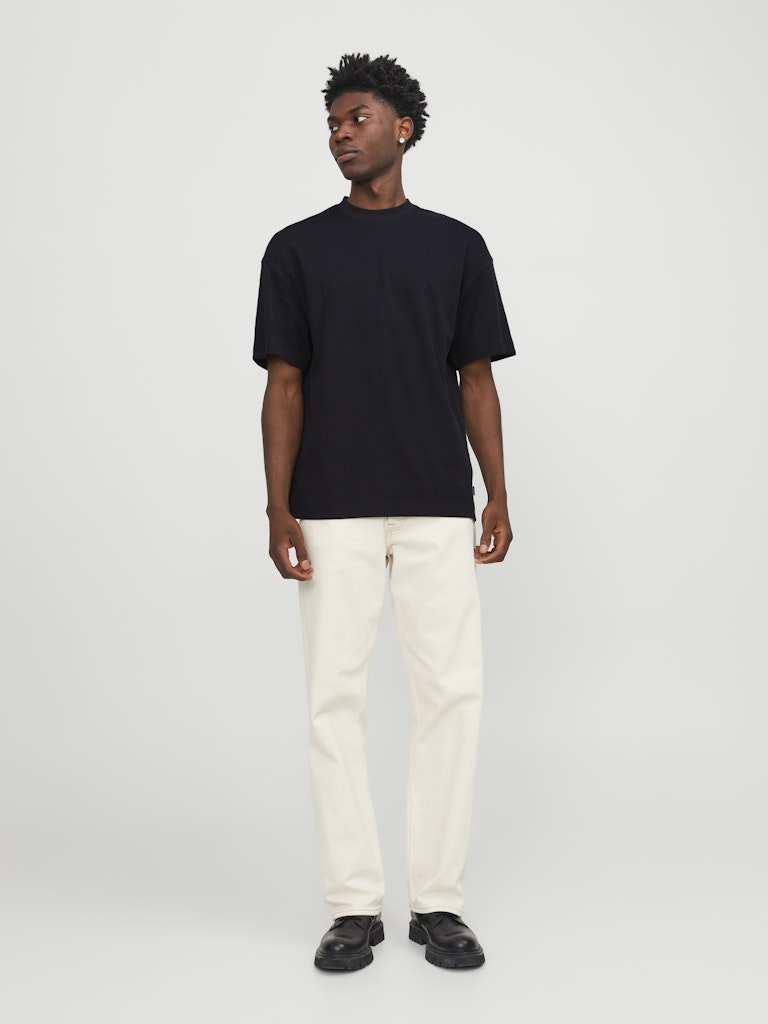 Person wearing a black t-shirt and white pants on a plain background