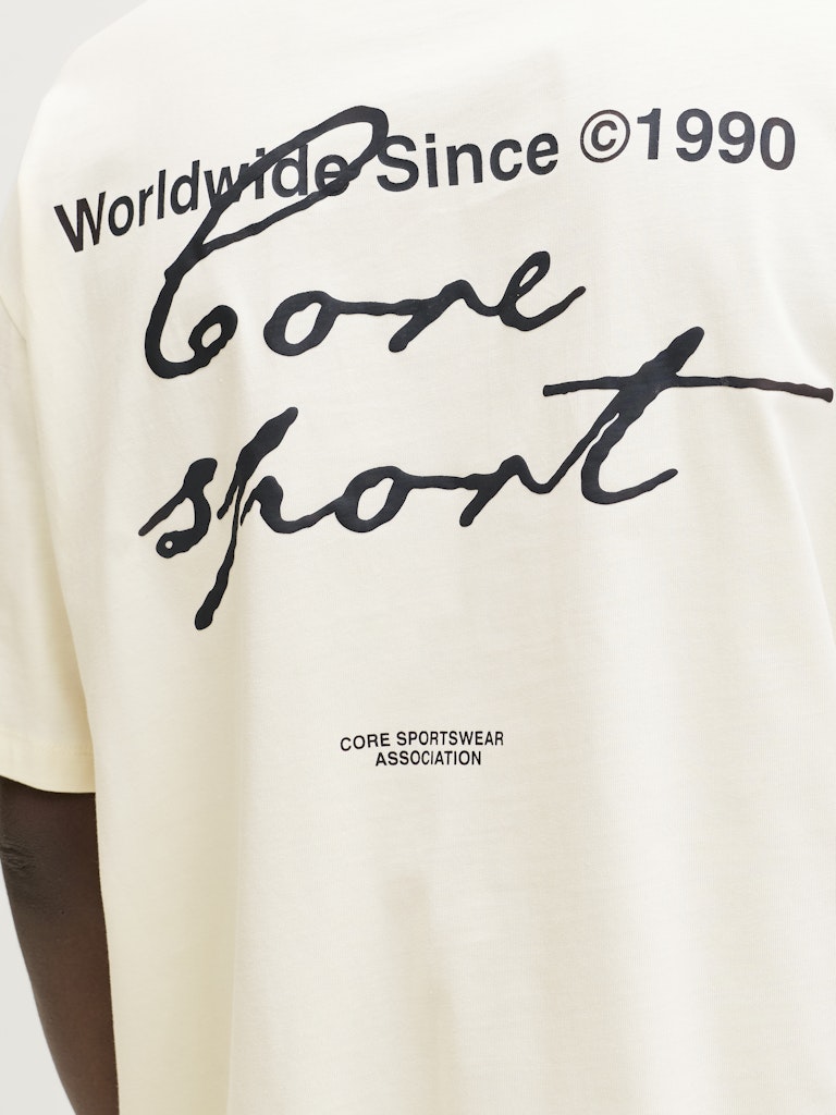 Yellow t-shirt with black text and branding on a person wearing it.