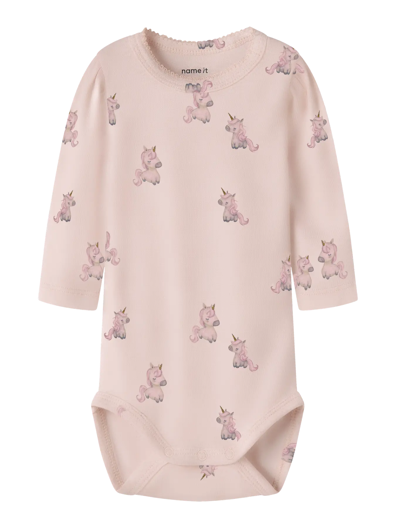 A pale pink long-sleeve baby bodysuit with an all-over print of small pink and lavender unicorns, featuring a crew neck and snap closures at the bottom. The brand name 'nome it' is printed inside the collar.