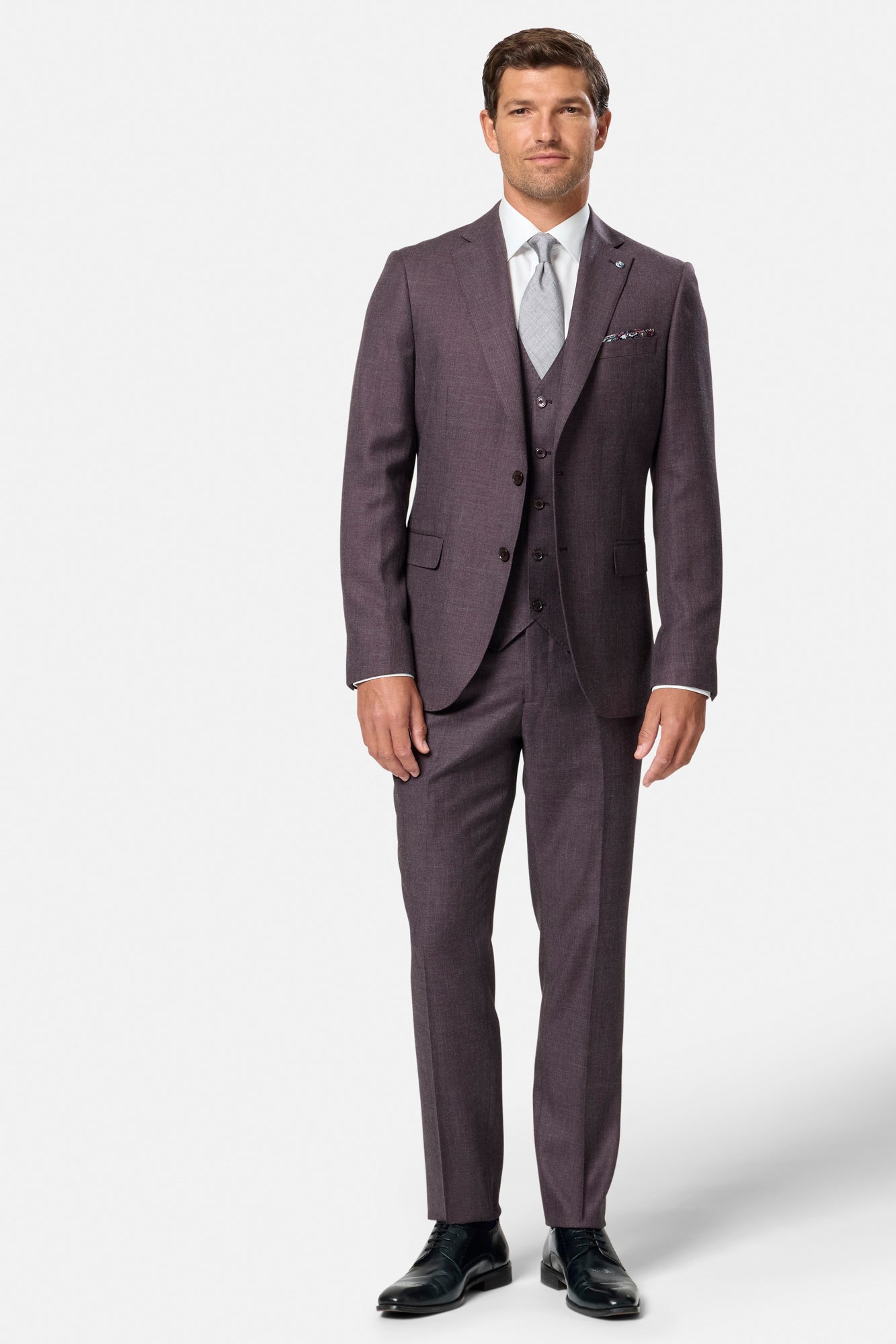 Man wearing a grape suit with a white shirt and tie on a white background