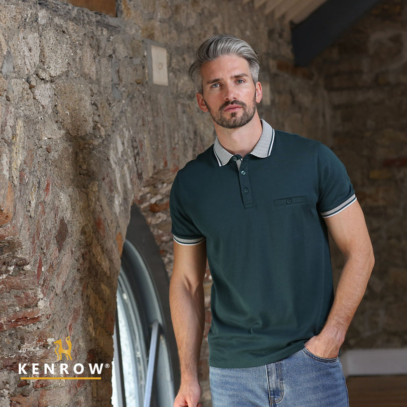 Man wearing a green polo shirt standing against a stone wall with 'Kenrow' branding.