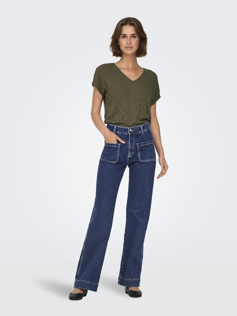 Woman wearing a green t-shirt and blue jeans on a white background