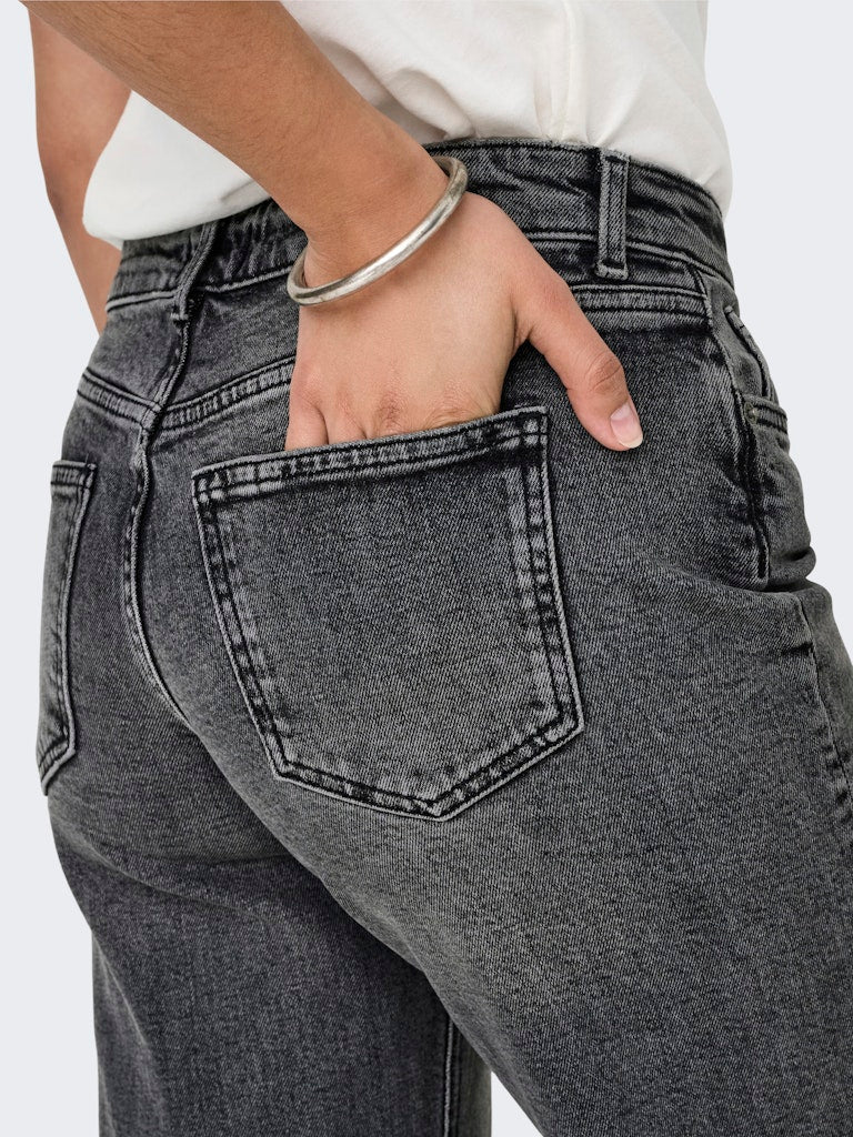 Person wearing gray jeans with a white background