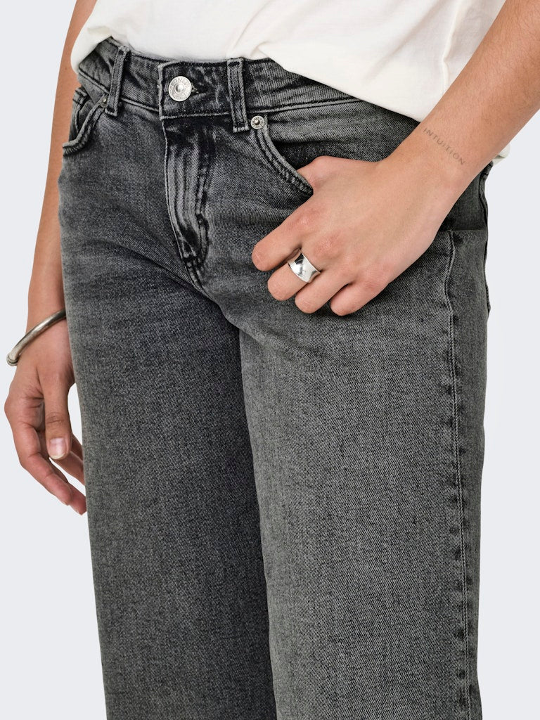 Person wearing gray jeans with a white background