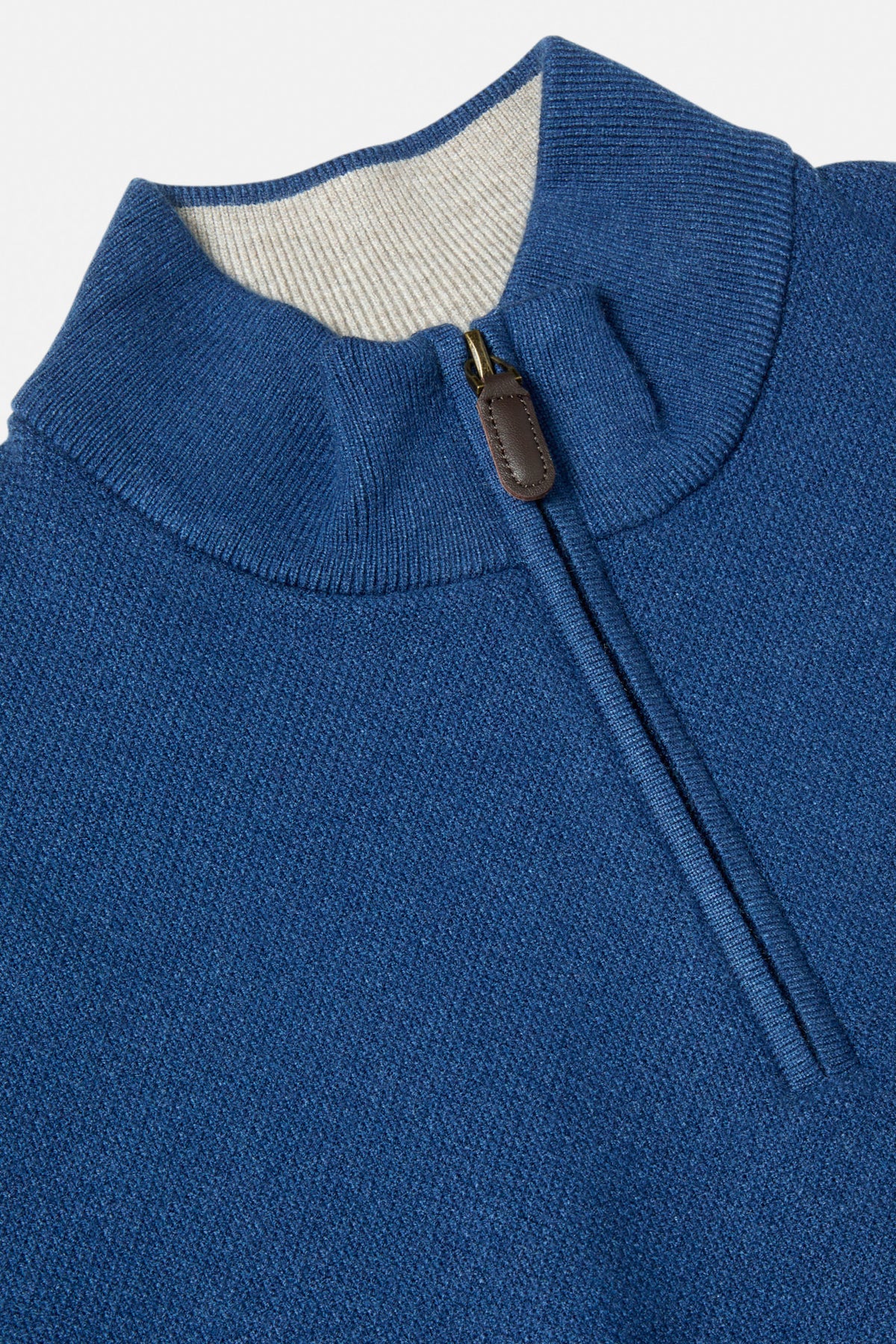 Close-up of the Benetti Quinn Indigo 1/4 Zip knit, showing the indigo ribbed collar and zip pull with contrast inner collar.
