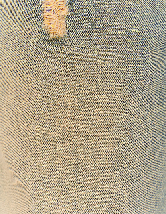Close-up of distressed detail on wide leg jeans