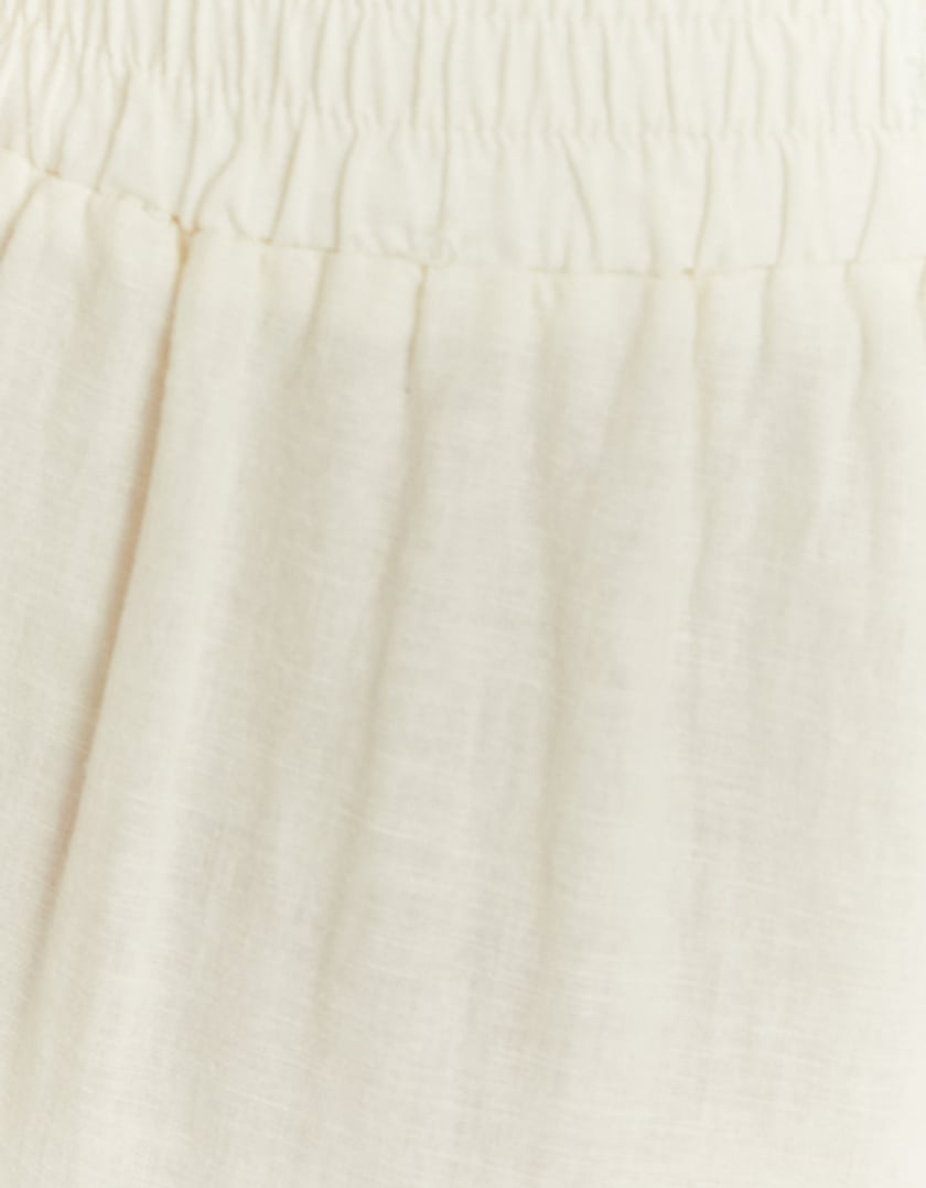 Close-up view of the white wide leg linen pants detail