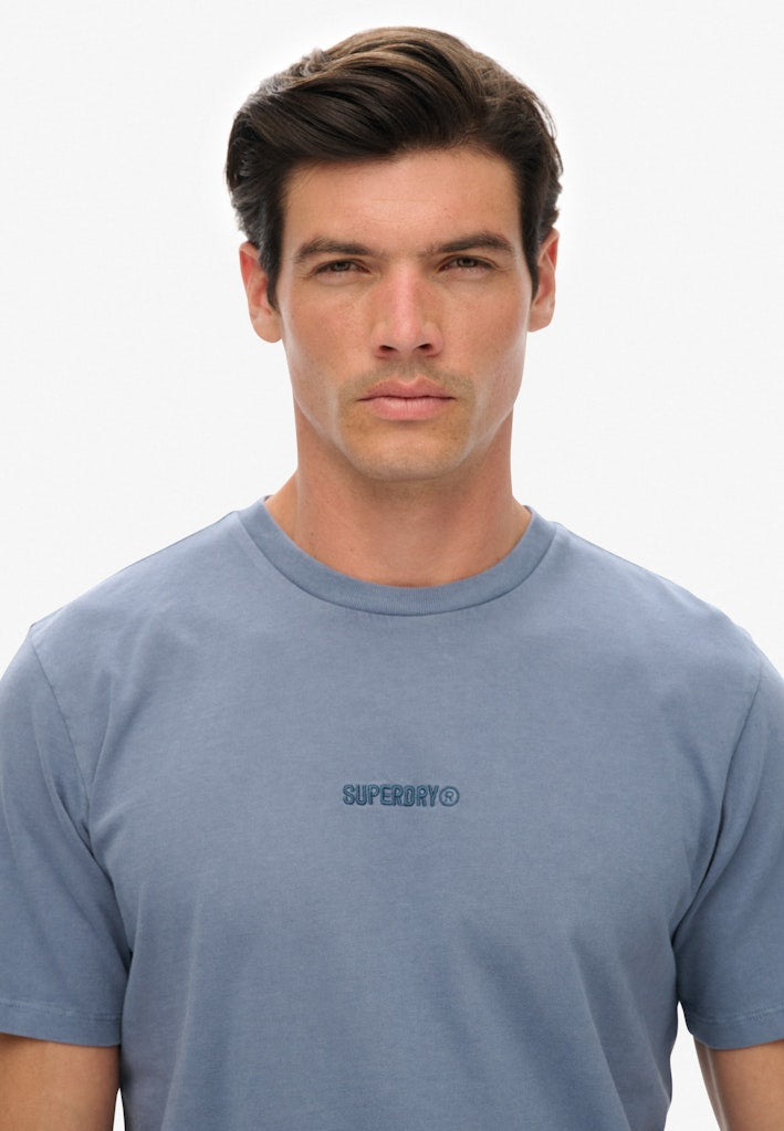 Man wearing a blue t-shirt with Superdry logo on a white background