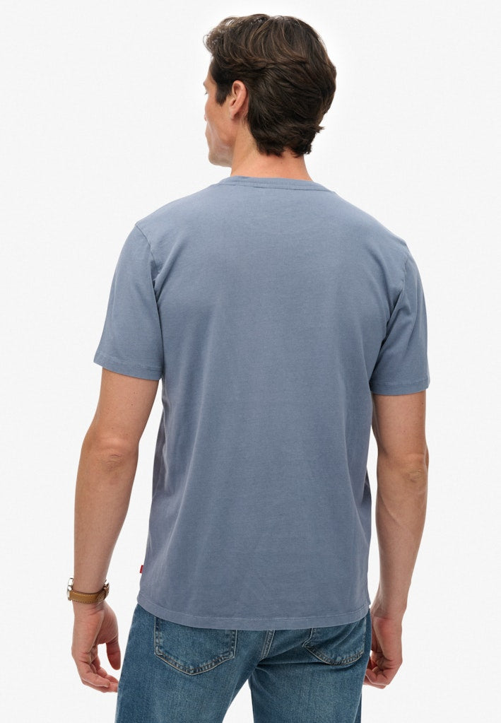Man wearing a blue t-shirt and jeans on a white background