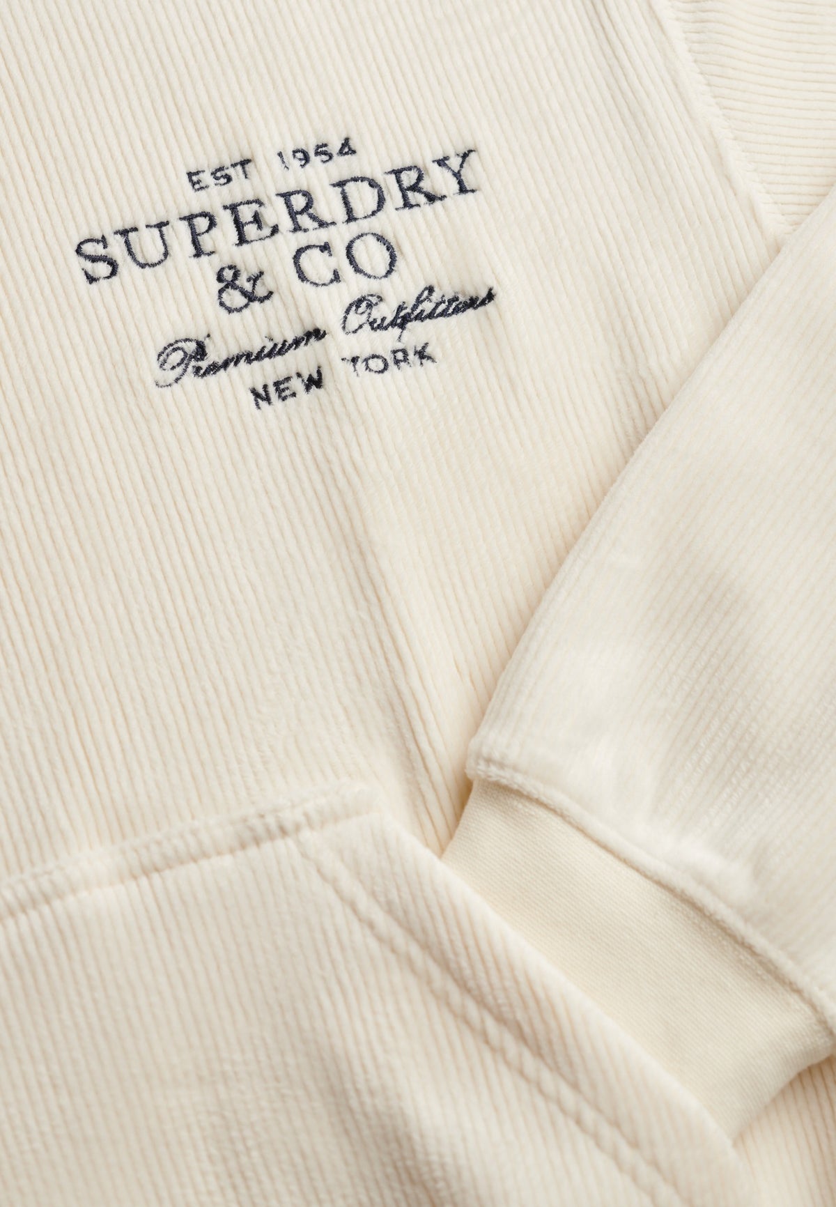 Embroidered logo detail on Superdry Drop Needle Velour Hoodie in Cream