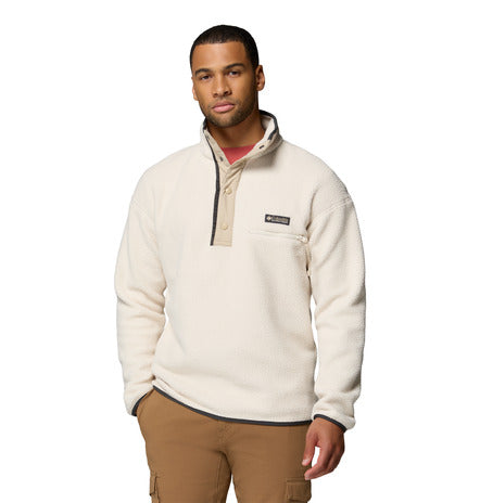 Man wearing a cream-colored fleece pullover with a brand logo on a white background