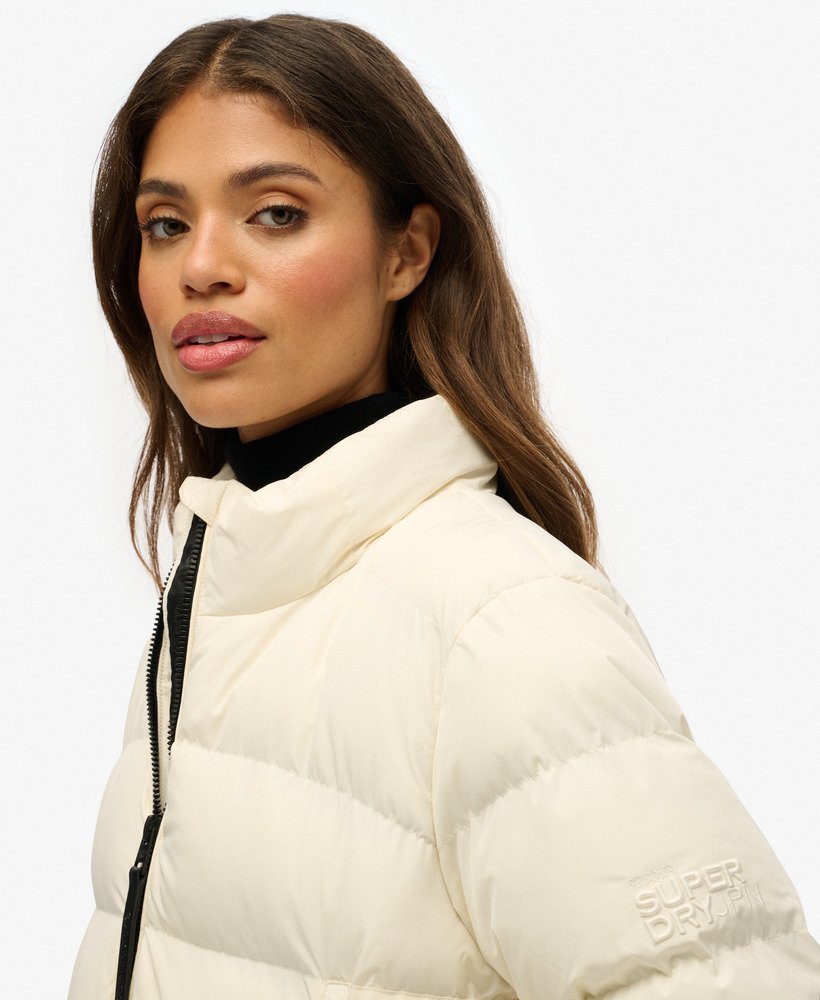 Woman wearing a white puffer jacket on a white background-Side view