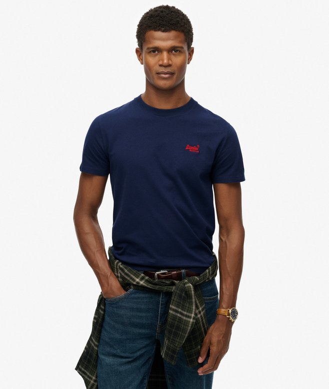Man wearing a navy blue t-shirt with a red logo on a white background