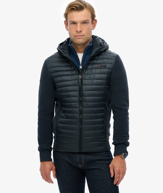 Man wearing a dark blue puffer jacket on a white background