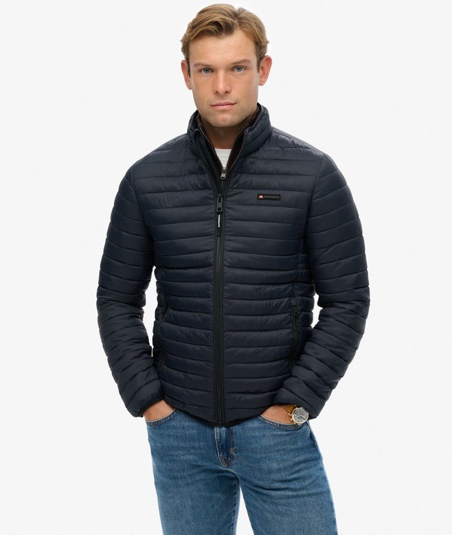 Man wearing a navy puffer jacket on a white background