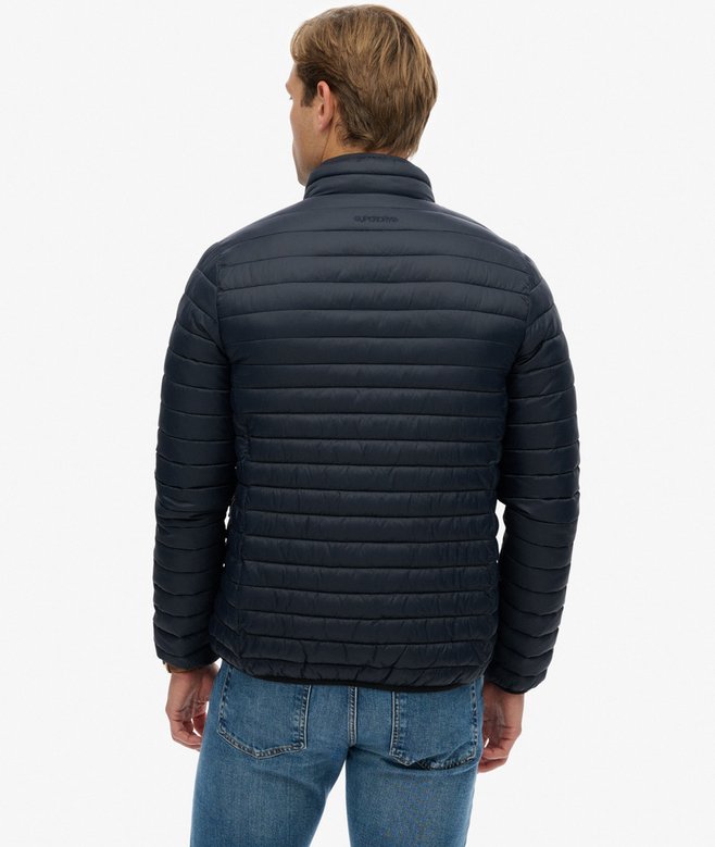 Man wearing a navy quilted jacket on a white background