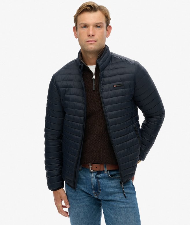 Man wearing a dark blue quilted jacket on a white background