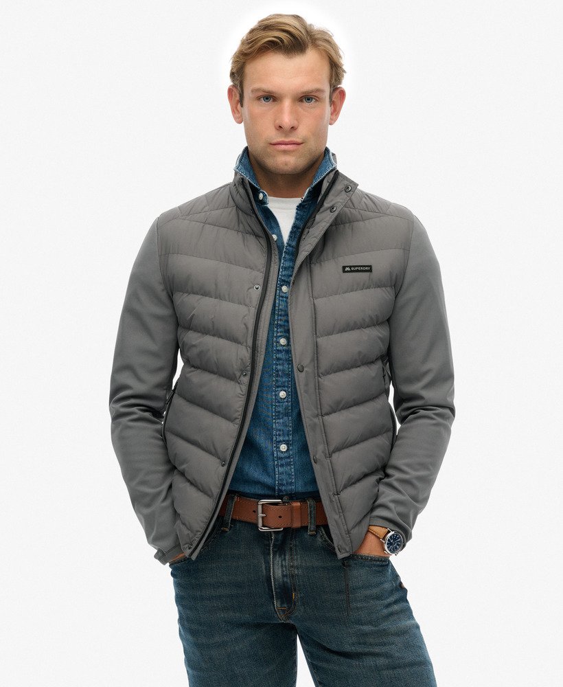 Man wearing a gray puffer jacket on a white background