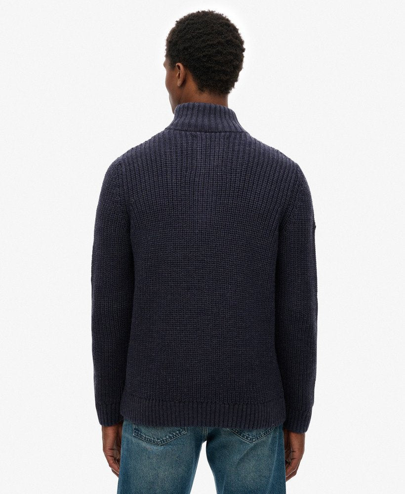 Person wearing a dark blue knitted sweater on a white background