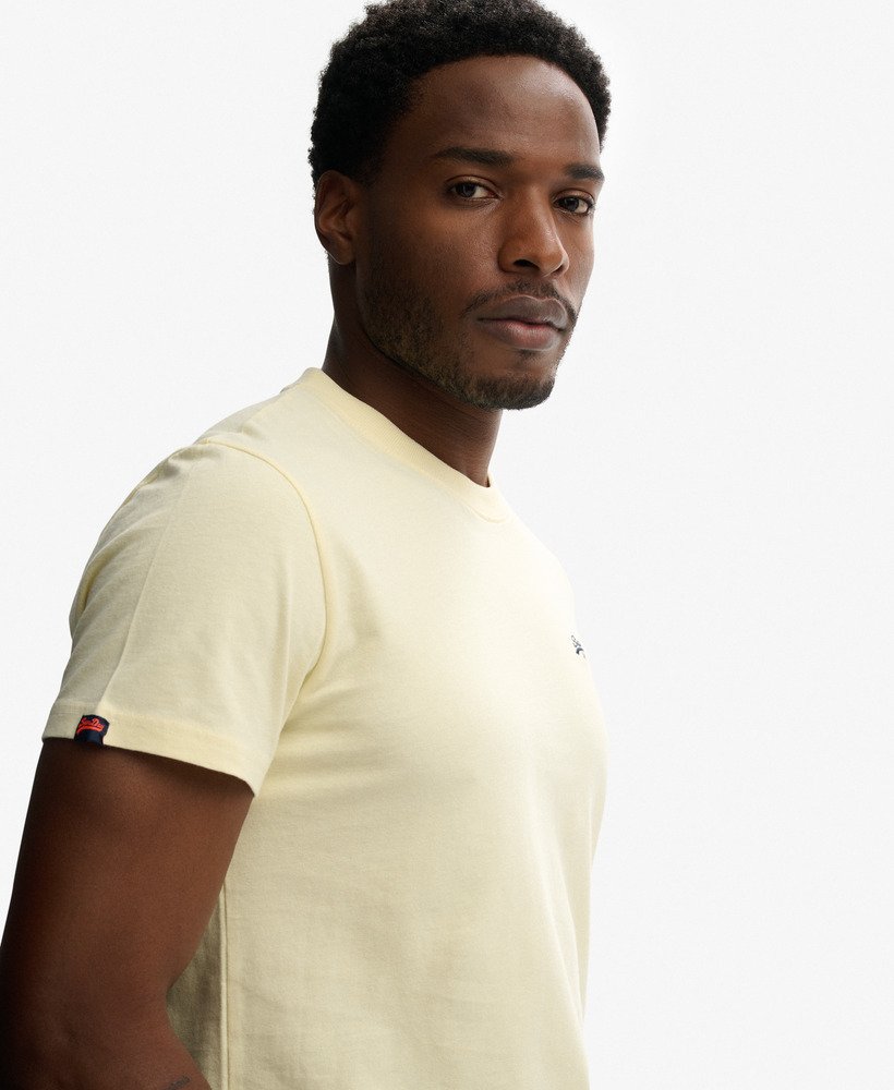 Man wearing a light yellow t-shirt on a white background