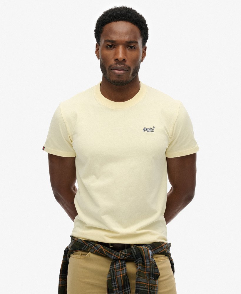 Man wearing a yellow t-shirt with a logo on a white background