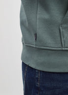 Diesel Jameson Hoodie in Green Meadow, close - up of the ribbed hem and small vertical Diesel logo tag.