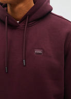 Diesel Julian hoodie in deep burgundy, close - up detail view showing the front logo patch and drawstrings