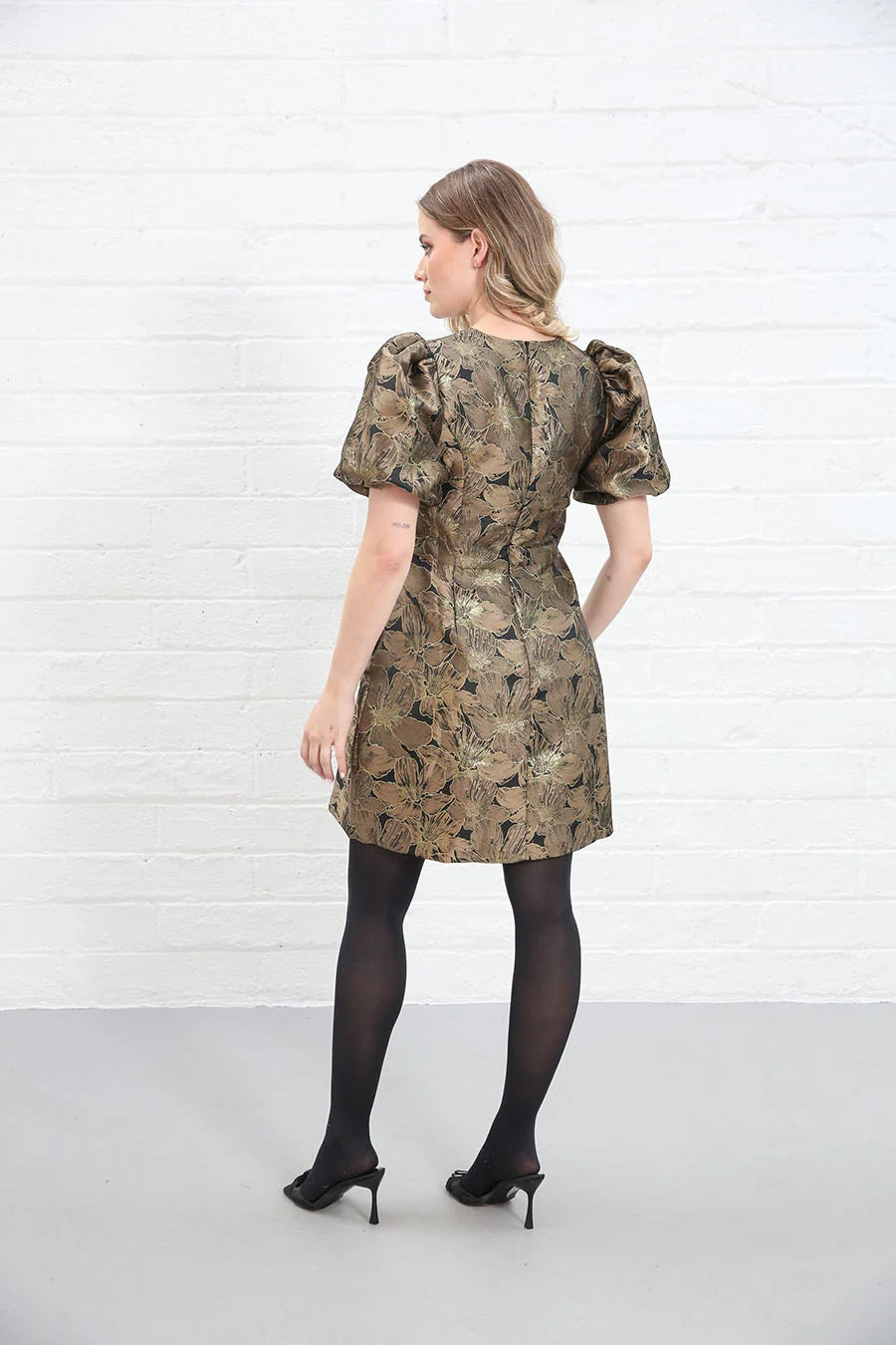 Rant & Rave Evelyn Dress in black and gold floral jacquard, back view worn by model with black tights and heels.