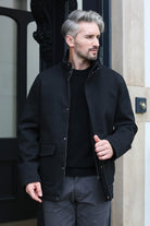 Kenrow Huxley Coat in black, angled model view showing zip and popper fastenings