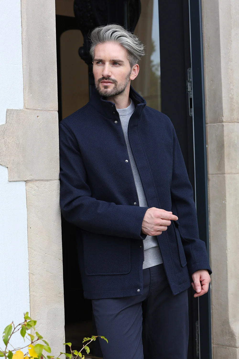 Kenrow Huxley Coat in navy worn by a model in an angled front view, styled over grey trousers