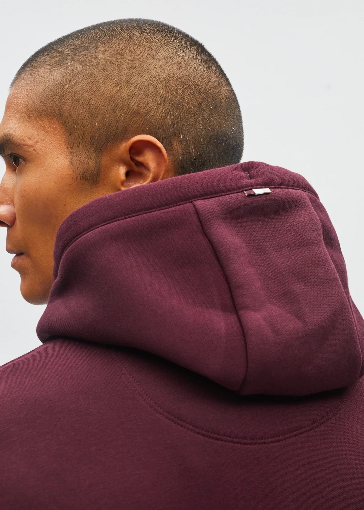 Diesel Julian hoodie in deep burgundy, side model view showing the hood and shoulder details